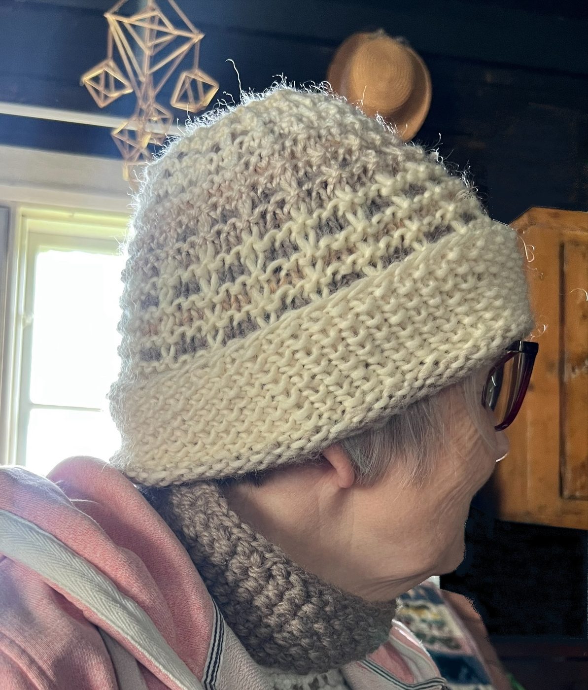 Model wearing the Vohveli waffle-stitch hat in beige and cream with a turned brim